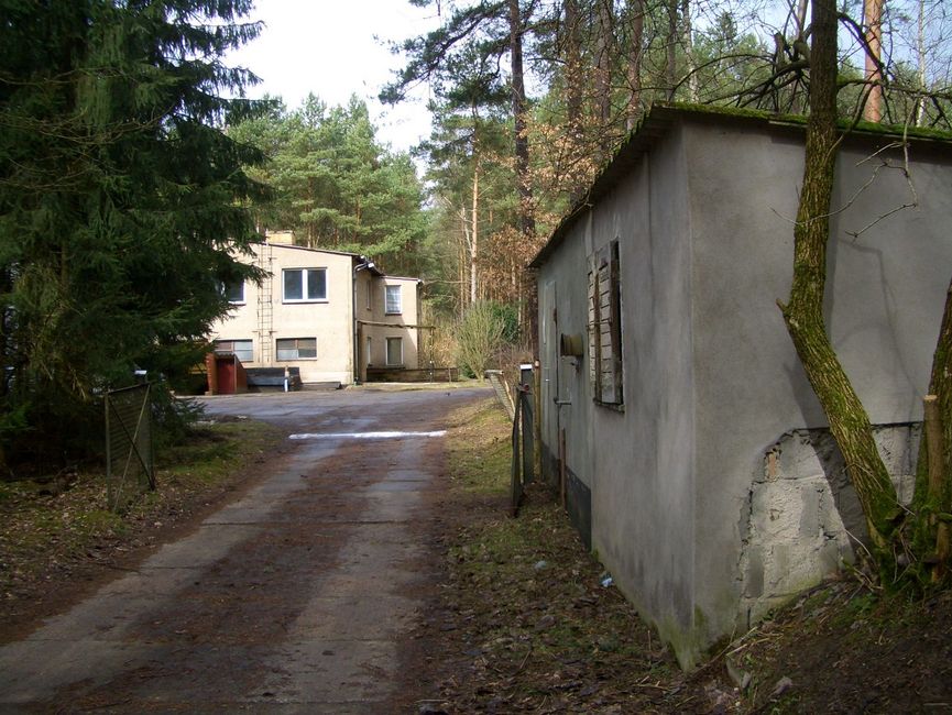 Hintergrund: Bürogebäude, rechts: Pumpstation mit Feuerlöschteich