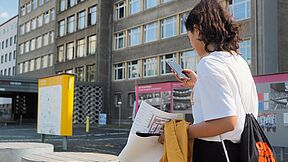 Eine Schülerin steht mit einem Smartphone in der Hand im Innenhof der "Stasi-Zentrale. Campus für Demokratie".