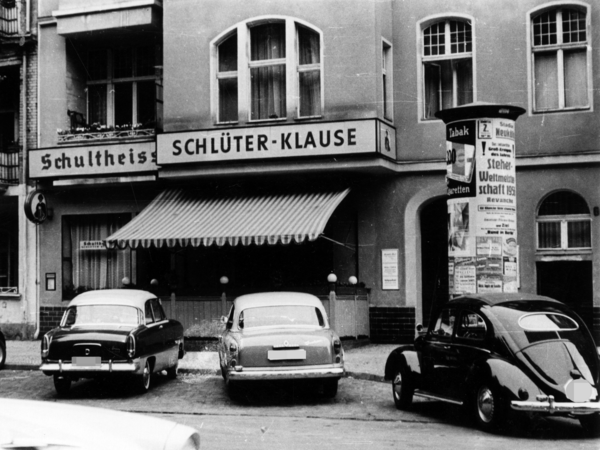 Das Schwarz-Weiß-Bild zeigt ein Lokal am Kurfürstendamm in West-Berlin. Davor parken einige Autos.