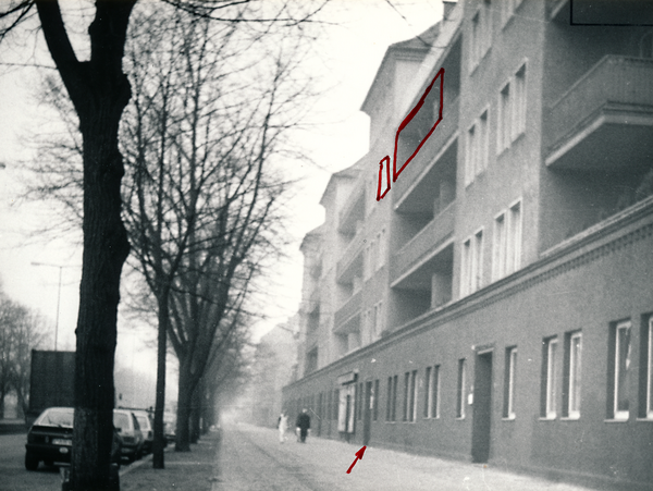 Schwarzweißaufnahme von Jürgen Fuchs’ Wohnhaus in West-Berlin. Die zu seiner Wohnung gehörenden Fenster sind rot markiert. Ein Pfeil markiert die zugehörige Haustür.